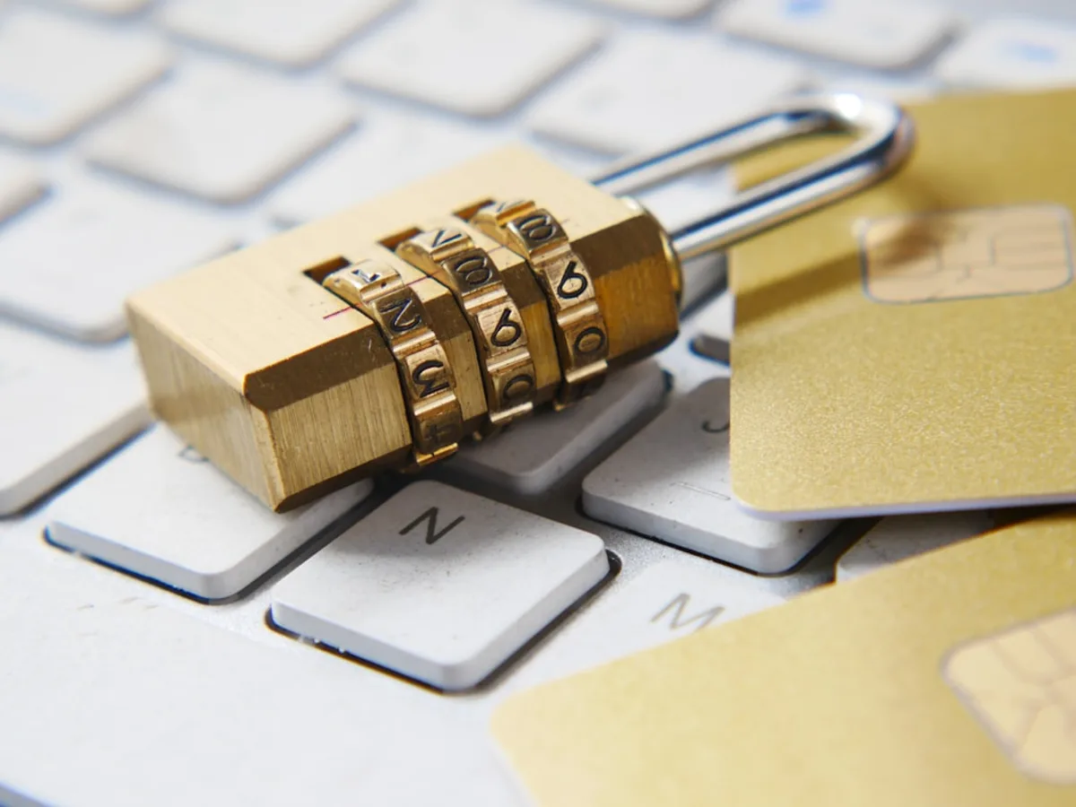 Gold padlock resting on a keyboard beside gold credit cards, representing GiveTurn's web security service